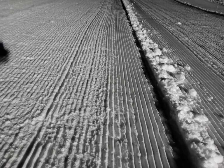 Frisch präparierte Piste mit gleichmäßigen Rillen im Schnee