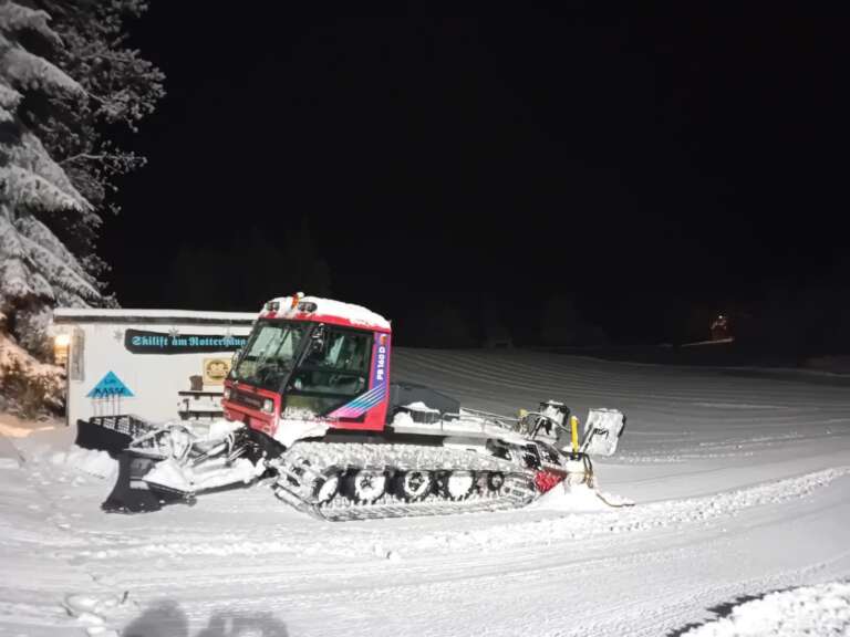 Pistenraupe vor der Talstation des Skilifts am Abend