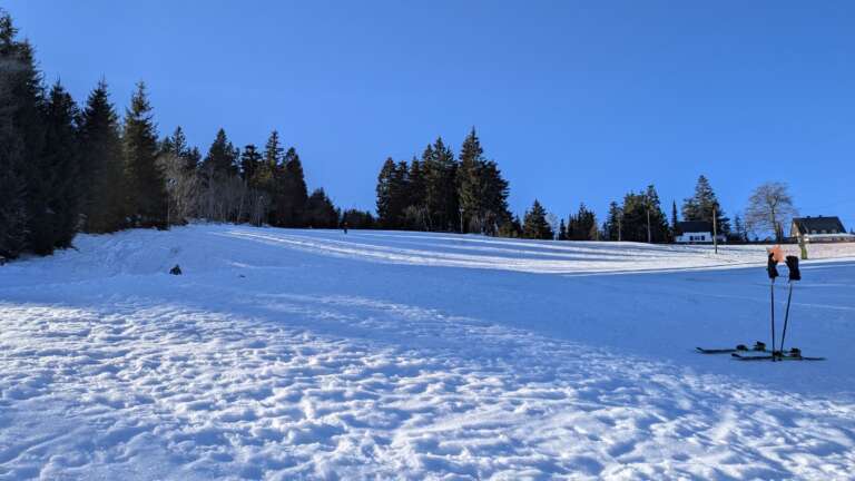 Ski und Skistöcke stecken im Neuschnee am Rotterhang