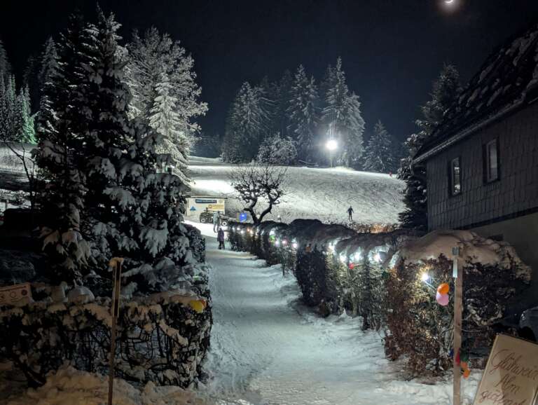 Verschneiter Weg zum Skilift am Rotterhang, im Hintergrund der Hang im Flutlicht